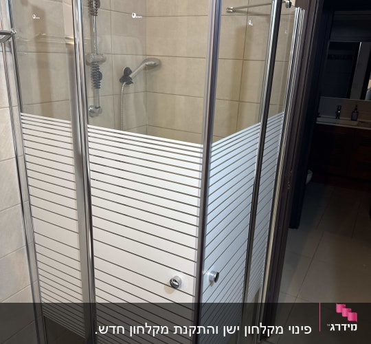 מקלחון זכוכית עם דלתות מתכת בחדר אמבטיה